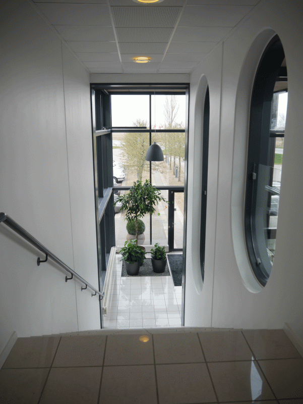 virksomhedsindretning af trappe til stueetage med hvidt teglgulv