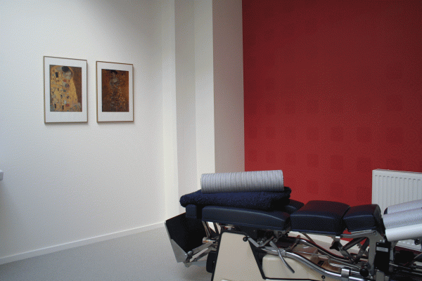 Business feng shui indretning hos kiropraktor med rødt tapet og malerier