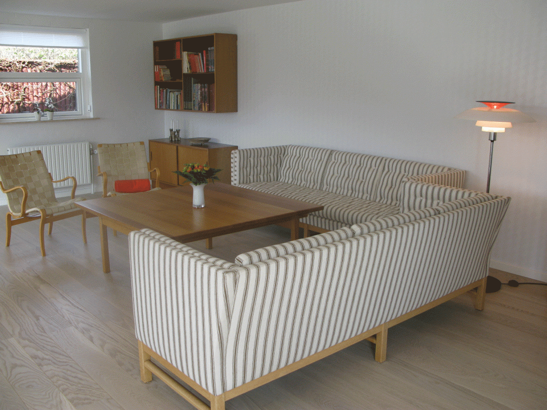 boligindretning af stue med stribede sofaer og trægulv