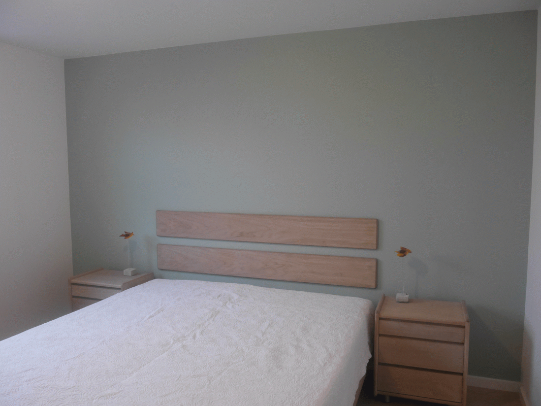 minimalistisk stueindretning med hvid seng og sengeborde i træ